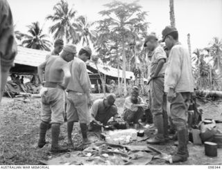 MUSCHU ISLAND, NEW GUINEA. 1945-10-27. JAPANESE SOLDIERS PREPARING A MEAL OF COPRA (DRIED COCONUT), RICE AND ORDINARY JUNGLE GRASS WHICH THEY MIX TOGETHER. THEY TOLD THE CAMERA MAN IT WAS GOOD ..
