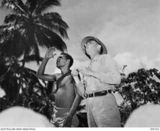 NEW GEORGIA. C.1943. AN AMERICAN METEOROLOGIST INSTRUCTING THE NATIVE RADIO OPERATOR WORKING WITH THE COASTWATCHER LIEUTENANT KENNEDY. (NAVAL HISTORICAL COLLECTION)