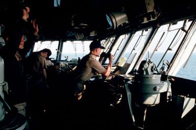 ENSIGN Stuart H. Johnston, right, keeps watch from the bridge of the amphibious assault ship USS SAIPAN (LHA 2) off the coast of North Carolina during the joint services exercise SOLID SHIELD '89