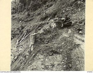 ZENAG, NEW GUINEA, 1944-02-27. A D6 ANGLE DOZER FROM NO.4 PLATOON, 2/1ST MECHANICAL EQUIPMENT COMPANY, ROYAL AUSTRALIAN ENGINEERS, CLEARING AN EARTH SLIDE FROM THE ROAD