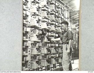 LAE, NEW GUINEA. 1944-04-03. VX106965 CORPORAL A MURCHIE, 19TH LINES OF COMMUNICATION SIGNALS, AT THE TWELVE CHANNEL TELEGRAPH TERMINAL