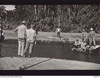 NASSAU BAY, NEW GUINEA. 1943-08-16. TROOPS OF THE 542ND ENGINEER BOAT AND SHORE REGIMENT, UNITED STATES FORCES, MOVING ACROSS A SMALL CREEK ON A PUNT. ON THE PUNT, STANDING: 35208880 WILLIAM ..