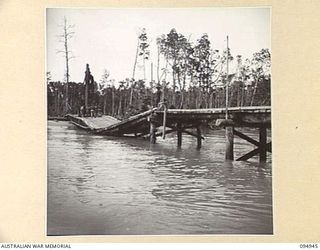 CAPE WOM, WEWAK AREA, NEW GUINEA. 1945-08-07. WHEN FLOODWATERS COME DOWN FROM THE HILLS, BRIDGES ARE WRECKED AND ROAD WASHAWAYS OCCUR. ENGINEERS WORK THE CLOCK ROUND AT TOP SPEED TO BRING ROADS ..