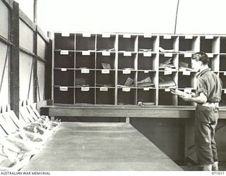 PORT MORESBY, PAPUA, NEW GUINEA. 1944-03-13. VX19861 SIGNALMAN K.J. MCDOWELL SORTING MAIL IN THE DESPATCH RIDER LETTER SERVICE OFFICE AT THE 18TH LINES OF COMMUNICATION SIGNALS, HEADQUARTERS NEW ..