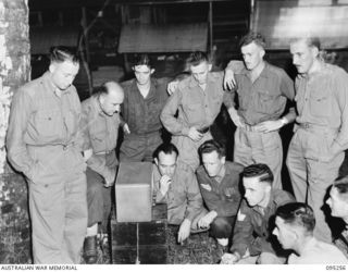 A group of Headquarters 11 Division listening to the radio for news of the projected Japanese surrender.  The new radio station 9AE operated by Australian Army Amenities Service is taking the ..