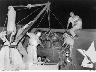 1943-04-01. NEW GUINEA. THREE TON AMERICAN TRUCKS DISMANTLED AND LOADED INTO TRANSPORT 'PLANES BY AMERICANS AND AUSTRALIANS FOR SHIPMENT TO WAU. (NEGATIVE BY N. BROWN)