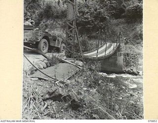 WAU - LAE ROAD, NEW GUINEA, 1944-02-20. A SUSPENSION BRIDGE BUILT BY AUSTRALIAN ARMY ENGINEERS ACROSS THE BULOLO RIVER SIX AND A HALF MILES FROM WAU. IT REPLACES A BRIDGE LDESTROYED BY AUSTRALIAN ..