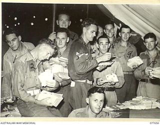 JACQUINOT BAY, NEW BRITAIN. 1944-12-19. PERSONNEL OF THE CAMP STAFF OFFICE, HEADQUARTERS, 5TH DIVISION SORTING THE UNIT CHRISTMAS MAIL. IDENTIFIED PERSONNEL ARE:- NX87103 PRIVATE E. TURNBULL (1); ..