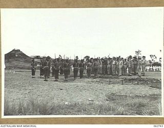 BOMANA WAR CEMETERY, PAPUA, NEW GUINEA. 1943-12-29. AT THE CONCLUSION OF A MEMORIAL SERVICE CONDUCTED BY CHAPLAIN J. D. MCKIE, CHURCH OF ENGLAND, A FIRING PARTY IN CHARGE OF QX226 SERGEANT N. L. ..