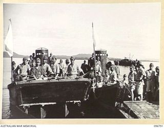 SORAKEN, BOUGAINVILLE, 1945-09-17. TWO JAPANESE BARGES, EACH WITH WHITE FLAG, WAITING FOR INSTRUCTIONS TO MOVE OFF AFTER BEING LOADED WITH SEVEN TONS OF RATIONS. THE RATIONS ARE FOR DISTRIBUTION TO ..