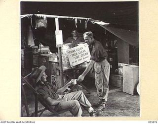 WIRUI BEACH, WEWAK AREA, NEW GUINEA. 1945-08-31. WARRANT OFFICER J.C. O'BRIEN, 2/1 FIELD AMBULANCE (1), RECEIVING A CUP OF TEA FROM PRIVATE L.G. BANGSUND, THE YMCA ATTENDANT (2)