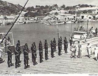 PORT MORESBY, PAPUA, 1953. NATIVE POLICE MEMBERS OF THE ROYAL PAPUA AND NEW GUINEA CONSTABULARY CORONATION CONTINGENT LINE UP ON THE DOCK PRIOR TO EMBARKATION FOR LONDON