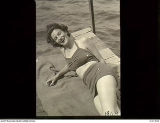 MADANG, NEW GUINEA. C. 1944-10. SISTER E. M. BEGG, MELBOURNE, VIC, BASKING IN HER SWIMMING COSTUME IN THE WARM NEW GUINEA SUNSHINE AFTER A HARD DAY'S WORK AT THE MEDICAL RECEIVING STATION IN NEW ..