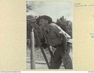 BOUGAINVILLE. 1945-04-28. CAPTAIN R.B. MCLEAN, 53 FIELD PARK COMPANY, ROYAL AUSTRALIAN ENGINEERS, SIGHTING DUMPY LEVEL DURING THE CONSTRUCTION OF AN AIRSTRIP FOR RAAF AUSTER AIRCRAFT SOUTH OF THE ..