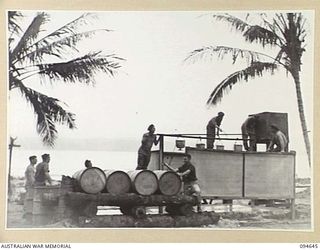 TOL, NEW BRITAIN, 1945-08-01. TROOPS OF 52 TRANSPORT PLATOON, AUSTRALIAN ARMY SERVICE CORPS, ERECTING A WATER TANK TO SUPPLY WATER TO SHOWERS ON THE BEACH AT THE TRANSPORT PLATOON CAMP