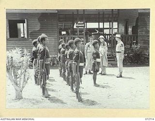 WAU, NEW GUINEA. 1944-04-25. THE HONOURABLE E.J. WARD, MINISTER FOR EXTERNAL TERRITORIES IN THE AUSTRALIAN GOVERNMENT (1), AT AREA COMMAND HEADQUARTERS, PREPARING TO INSPECT A GUARD OF HONOUR ..