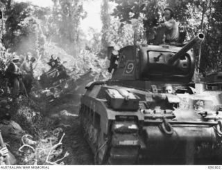BOUGAINVILLE. 1945-03-31. A MATILDA TANK OF 2/4 ARMOURED REGIMENT BEING PULLED FROM A BOG BY ANOTHER TANK WHICH HOOKED UP AND HOISTED IT BACK TO THE ROAD DURING THEIR ADVANCE TOWARDS THE HONGORAI ..