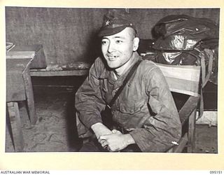 TOKO, BOUGAINVILLE, 1945-08-18. SUPERIOR PRIVATE TAKESHITA, FLAG BEARER ACCOMPANYING MAJOR OTSU, SURRENDER ENVOY FROM LIEUTENANT-GENERAL M. KANDA, COMMANDER IMPERIAL JAPANESE 17 ARMY GROUP, SMILING ..