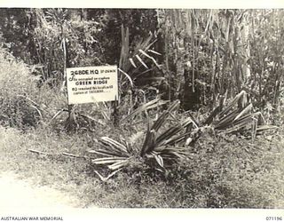 FINSCHHAFEN AREA, NEW GUINEA, 1944-03-17. ONE OF MANY BATTLE SIGNS IN THE AREA, THIS SIGN MARKS THE SITE OF HEADQUARTERS, 26TH INFANTRY BRIGADE, FOLLOWING THE CAPTURE OF GREEN RIDGE IN THE BATTLE ..