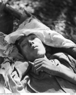 PAPUA, NEW GUINEA. 1942-10. JAPANESE PRISONER CAPTURED NEAR NAURO. HE HAD BEEN OVERWORKED AND WAS NEARLY STARVING WHEN TAKEN PRISONER. HE IS SEEN LYING ON A STRETCHER AFTER BEING CARED FOR BY ..