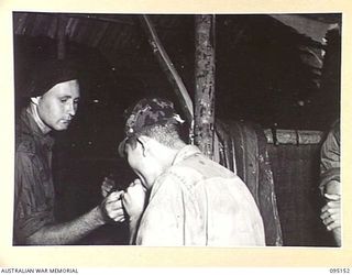 TOKO, BOUGAINVILLE, 1945-08-18. AUSTRALIAN SOLDIER, B. SHEM, GIVING MAJOR OTSU A LIGHT IN THE ANTE-ROOM AT HEADQUARTERS 3 DIVISION AFTER INTERROGATION. MAJOR OTSU IS THE SURRENDER ENVOY FROM ..