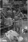 Mortuary ceremony: pregnant woman wearing fiber skirt, next to taro, skirts, banana leaf bundles (wealth items)