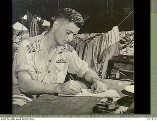 MOMOTE, LOS NEGROS ISLAND, ADMIRALTY ISLANDS. C. 1944-04. WRITING AT HIS DESK, THE COMMANDING OFFICER OF THE FAMOUS KITTYHAWK SQUADRON, NO. 76 SQUADRON RAAF, SQUADRON LEADER IAN S. LOUDON DFC, WHO ..