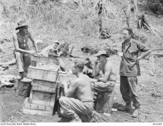 WALINGAI BEACH, NEW GUINEA. 1944-01-02. MEMBERS OF THE 27TH PLATOON, 2/6TH SUPPLY DEPOT COMPANY AND AN AMERICAN FRIEND HAVING LUNCH DURING THE HUON PENINSULA CAMPAIGN. SHOWN ARE: NX46179 PRIVATE N. ..