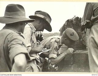 FORTIFICATION POINT, NEW GUINEA. 1944-04-06. VX80896 MAJOR R.C. GROVER (1), AN OFFICER OF THE OPERATIONAL RESEARCH SECTION, ARMY ORDNANCE CORPS NOTING THE IMPACT MADE BY A SHELL FIRED FROM A ..