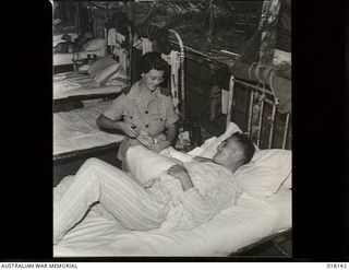 Aitape, New Guinea. 1945. Lieutenant Chaseley McLean of Mackay, Qld, gives physiotherapy treatment to Private J. Nettleton, a patient at the Australian General Hospital