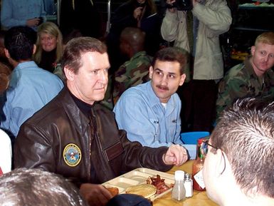 Secretary of Defense William S. Cohen shares breakfast with Quartermaster 1ST Class Michael Howard and other sailors and marines aboard the amphibious assault ship USS GUAM (LPH 9). Cohen and his wife Janet, celebrated the holiday with some of the more than 230,000 service members stationed throughout Europe this Christmas