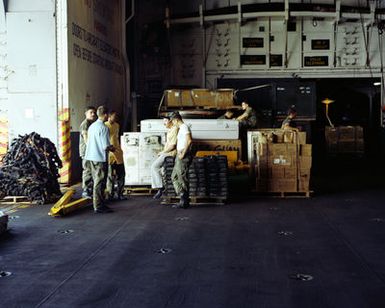 US Marines inspect supplies stored on the hangar deck of the amphibious assault ship USS GUAM (LPH 9), stationed off the coast of Beirut. The ship is providing support to US Marines deployed in Lebanon as part of a multi-national peacekeeping force following confrontation between Israeli forces and the Palestine Liberation Organization