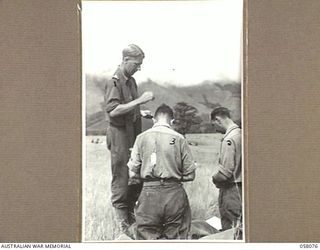 RAMU VALLEY, NEW GUINEA. 1943-10-20. SX11061 PADRE H. NORMAN, (CHURCH OF ENGLAND), ADMINISTERS HOLY COMMUNION TO MAJOR OWENS (LEFT) AND LIEUTENANT MOORE, IN THE 21ST AUSTRALIAN INFANTRY BRIGADE ..