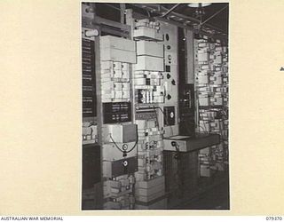 LAE, NEW GUINEA. 1945-03-11. THE ENTIRE INSTRUMENT BOARD OF THE LAE CARRIER TELEPHONE STATION. ON THE LEFT IS THE CS5 CARRIER TERMINAL WHILE ON THE RIGHT IS THE 40CI TELEGRAPH SYSTEM