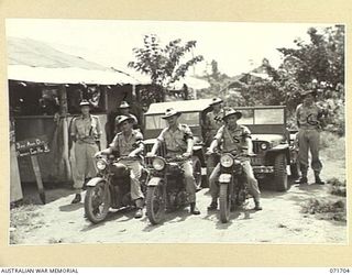 LAE, NEW GUINEA, 1944-03-25. MEMBERS OF THE 3RD DIVISION PROVOST COMPANY ATTACHED TO HEADQUARTERS LAE BASE SUB-AREA WITH VEHICLES OUTSIDE HEADQUARTERS. THE MOTOR CYCLE AND JEEP PATROLS ARE USED IN ..