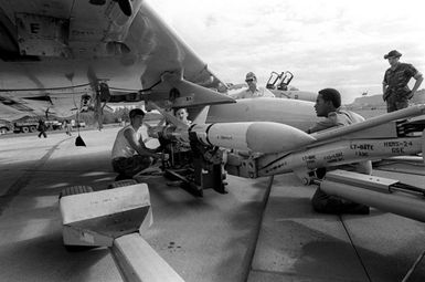 Men from Marine Fighter Attack Squadron 235 (VMFA-235) load an AIM-7 Sparrow III missile aboard an F-4 Phantom II aircraft