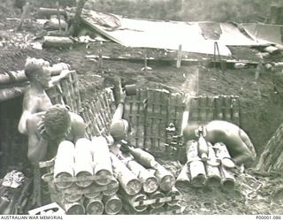 THE SOLOMON ISLANDS, 1945-03-27. AUSTRALIAN MORTAR CREW SHIELDING THEMSELVES FROM THE NOISE AND BLAST OF THEIR WEAPON AS IT FIRES A ROUND NEAR THE NUMA NUMA TRAIL ON BOUGAINVILLE ISLAND. (RNZAF ..