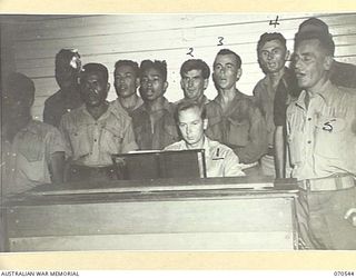 PORT MORESBY, PAPUA, 1944-02-20. GILBERT BRICHTER, OF DETROIT, MICHIGAN (1) A SERVICEMAN WHO TAUGHT MUSIC IN CIVILIAN LIFE, PLAYING THE ORGAN IN ACCOMPANIMENT TO A CHOIR OF AMERICAN, AUSTRALIAN AND ..