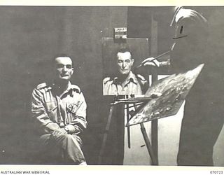 PORT MORESBY, PAPUA, NEW GUINEA, 1944-02-02. VX93433 CAPTAIN W.A. DARGIE (1), OFFICIAL WAR ARTIST, MILITARY HISTORY SECTION, LECTURING AND DEMONSTRATING PORTRAIT PAINTING USING QX27970 SERGEANT W. ..