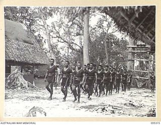 CAPE CUNNINGHAM, NEW BRITAIN, 1945-08-15. MEMBERS OF THE ROYAL PAPUAN CONSTABULARY MARCH PAST THEIR MAIN ORDERLY ROOM AS THEY GO ON PARADE FOR THE FIRST TIME AFTER THE ALLIED VICTORY. NEWS OF THE ..