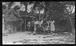 Group portrait by house and canoe