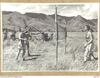 DUMPU AIRSTRIP, NEW GUINEA. 1943-11-14. GUNNERS OF THE 2/4TH AUSTRALIAN LIGHT ANTI-AIRCRAFT REGIMENT PLAYING CIRCLOIS DURING AN OFF DUTY PERIOD. THEIR 40 MM BOFORS GUN CAN BE SEEN IN THE ..
