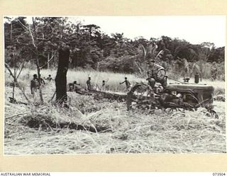 NARAKAPOR, NEAR NADZAB, NEW GUINEA. 1944-05-27. V240439 DRIVER S.F. JARDINE (1), NO.1 PLATOON, 6TH FARM COMPANY OPERATING ONE OF THE 4 TRACTORS AT THE UNIT TO "LOG UP" DURING A CLEARING PROGRAMME. ..