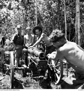 1942-12-31. PAPUA. BUNA. AN AUSTRALIAN MOUNTAIN BATTERY SHELLS BUNA. LEFT TO RIGHT. GUNNER G.E. MAIR (QLD), W.L. EVERETT (NSW), A. DIXON (NSW), A.E. BARRETT (NSW), SGT. L.B. GREENE (NSW), ..