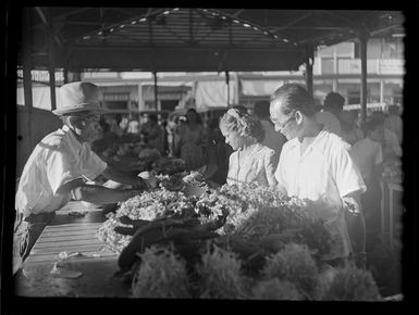 Market scene with people looking at food at stall, Papeete, Tahiti