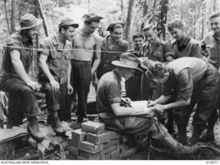 Goodview Junction, New Guinea. c. 1943-09. Australian troops voting in a Federal election as United States soldiers watch. The unit's electoral officer, Lieutenant Larry Drake of Darling, Victoria, ..