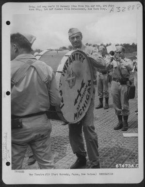 Gary Cooper plays the drum with the 32nd Division Band at his own reception at Port Moresby, Papua, New Guinea, 7 December 1943. Mr. Cooper and party were touring the Pacific Islands, entertaining U.S. Troops. (U.S. Air Force Number 67473AC)