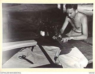 PALMALMAL PLANTATION, NEW BRITAIN. 1945-07-21. PRIVATE G. BOYD, 1 INFANTRY TROOPS WORKSHOP, WORKING IN THE UPHOLSTERY SECTION WHERE NEW HOODS AND SEATS ARE MADE. IN THE UNIT ALL PARTS FROM JEEPS ..