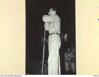 LAE, NEW GUINEA. 1944-07-24. LARRY ADLER, THE WORLD FAMOUS MOUTH ORGAN VIRTUOSO RENDERING AN ITEM DURING A CONCERT STAGED FOR THE TROOPS BY THE JACK BENNY SHOW