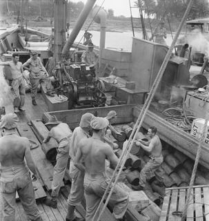 WIDE BAY, NEW BRITAIN. 1945-05-06. A WORKING PARTY FROM 11 INFANTRY BATTALION, AT WORK ABOARD THE AK 82 (FORMERLY THE ALMA-DOEPEL), 16 WATERCRAFT COMPANY, ROYAL AUSTRALIAN ENGINEERS, DISCHARGING A ..